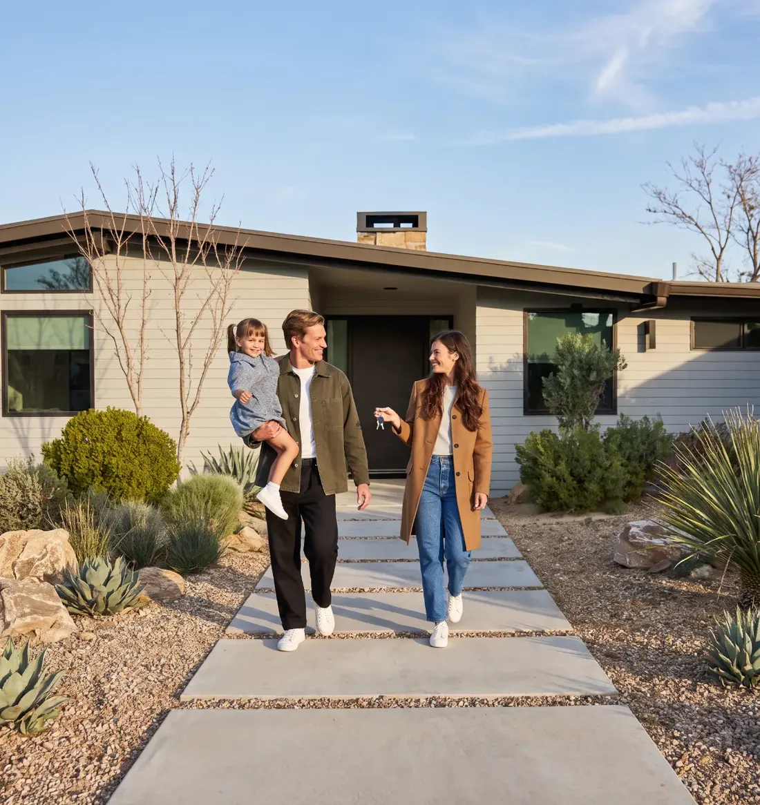 A young family walking out from their new home, keys in hand